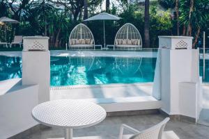 a table and chairs next to a swimming pool at Iberostar Selection Marbella Coral Beach in Marbella