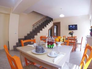 a dining room with a table and a staircase at BB Aretè in Scilla
