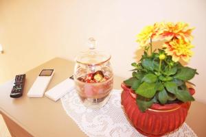 a table with a vase with flowers and a remote control at BB Aretè in Scilla