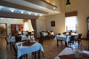 a restaurant with tables and chairs with white tablecloths at Hotel Restauracja Varia in Działdowo