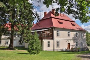 duży biały dom z czerwonym dachem w obiekcie Jizdarna Zamek Skalice w mieście Čkyně