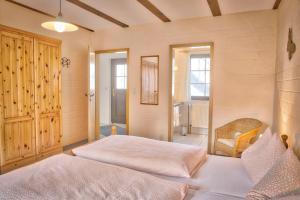 a bedroom with two beds and a chair at Landhotel Belitz Garni in Küsten