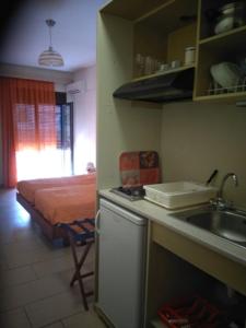 a kitchen with a sink and a bed in a room at Telethrio in Loutra Edipsou