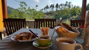 une table avec une assiette de nourriture et des tasses de café dans l'établissement La Bordigona, à Carrodano Inferiore