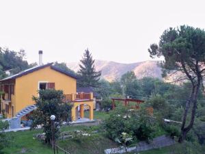 a yellow house with a balcony in a yard at La Bordigona in Carrodano Inferiore