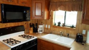 a kitchen with a stove and a sink and a microwave at Cedar Pines Resort in South Lake Tahoe