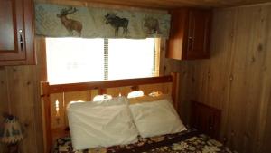 a bedroom with a bed and a window with deer on the curtain at Cedar Pines Resort in South Lake Tahoe
