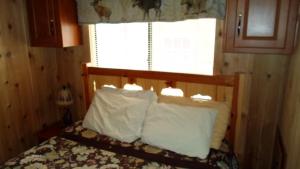 a bedroom with a bed with white pillows and a window at Cedar Pines Resort in South Lake Tahoe