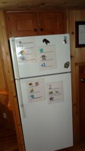a white refrigerator with magnets and papers on it at Cedar Pines Resort in South Lake Tahoe