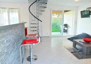 ポルト・ヴェッキオにあるJolie Mini-villa 70 m2のリビングルーム(階段、赤いスツール付)