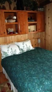 a bedroom with a bed with a green blanket at Cedar Pines Resort in South Lake Tahoe