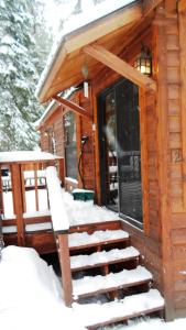 a log cabin with snow on the stairs at Cedar Pines Resort in South Lake Tahoe