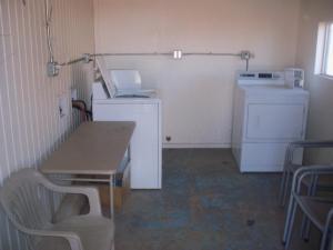 a kitchen with a table and a washer and dryer at Deluxe Inn Of Roswell in Roswell