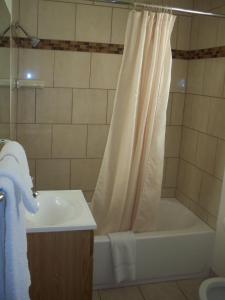 a bathroom with a shower curtain and a tub and a sink at National 9 Inn in Roswell