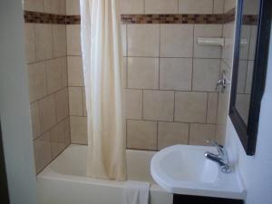 a bathroom with a shower curtain and a sink at National 9 Inn in Roswell