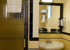 a bathroom with a sink and a shower with a mirror at Hotel Boheme in San Francisco