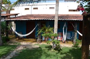 a blue house with a hammock in front of it at Pousada Bangalô in Jericoacoara