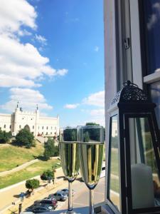 parę kieliszków do wina siedzących na parapecie w obiekcie Plac Zamkowy Apartment w mieście Lublin