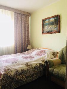 una camera con letto, finestra e sedia di Ra a Bukovel