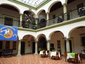 una stanza con tavoli, sedie e bandiera di Hotel Monte Alban - Solo Adultos a Città di Oaxaca