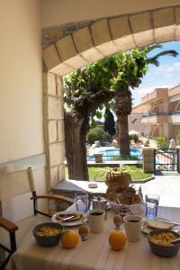 a table with bowls of food on top of it at Madena Apartments in Stoupa