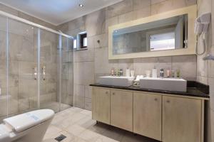 une salle de bain avec deux lavabos et une douche dans l'établissement Elafonisos Resort, à Elafonisos