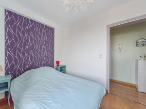 モンペリエにあるWelkeys - Quartier Antigone Apartmentの紫の壁のベッドルーム1室(ベッド1台付)