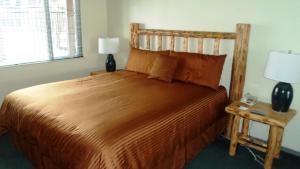 Un dormitorio con una cama grande y una mesa con una lámpara. en The Lodge at Lake Tahoe, a VRI resort, en South Lake Tahoe
