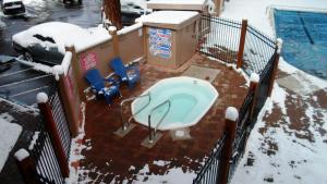 une baignoire dans la neige à côté d'une piscine dans l'établissement The Lodge at Lake Tahoe, a VRI resort, à South Lake Tahoe