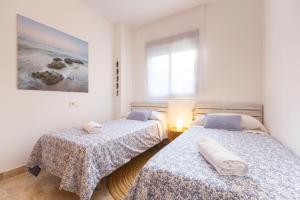 2 Betten in einem Zimmer mit weißen Wänden in der Unterkunft Oasis del Toyo in Retamar
