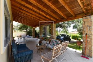 eine überdachte Terrasse mit Stühlen und einem Tisch in der Unterkunft Summer House Toula in Nea Kallikratia