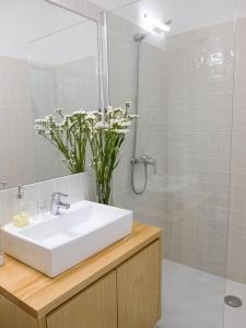 a bathroom with a white sink and a shower at Own Places Casa do Bonas in Porto