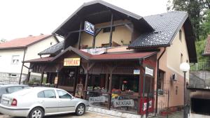 een gebouw waar een auto voor geparkeerd staat bij Restoran i sobe "Tocak" in Doboj