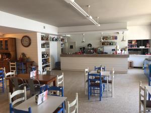 a restaurant with tables and blue chairs and a counter at Hostal Carabela in Areas
