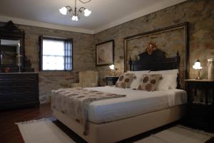 een slaapkamer met een groot bed en stenen muren bij Casa do Meio do Povo - Turismo de Habitação in Chaves +44 foto's