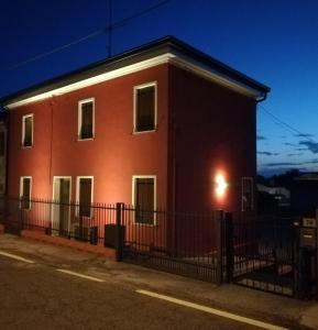 un edificio di mattoni rossi con una recinzione di fronte di Karingo House a Fratta Polesine