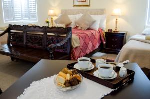 Zimmer mit einem Bett und einem Tisch mit einem Tablett mit Essen in der Unterkunft Annies House in Cradock
