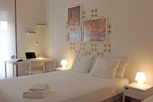 a bedroom with a bed and a desk with a laptop at Uporto House Villa in Porto