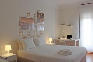 Uporto House Villa في بورتو: غرفة نوم بيضاء مع سرير ومكتب