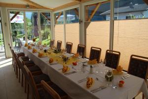 a long dining room with a long table and chairs at Frühstücks-Radpension Taurer-Thoman in Dellach im Drautal