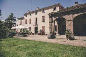 ein großes weißes Gebäude mit einer Terrasse und einem Hof in der Unterkunft La Luna nel Pozzo in Parma