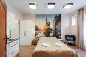 1 dormitorio con 1 cama con una pintura en la pared en Krakow For You Budget Apartments en Cracovia