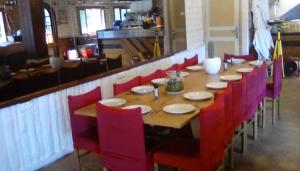 una mesa larga con sillas rojas en un restaurante en Grand Chalet Du Lac Du Boreon, en Saint-Martin-Vésubie