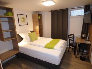 1 dormitorio con 1 cama y escritorio con ordenador en Hotel Art Inn Dinslaken en Dinslaken