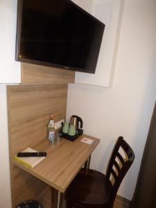 Hotel Art Inn Dinslaken في دينسلاكن: طاولة خشبية صغيرة مع تلفزيون على الحائط