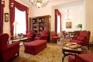 ein Wohnzimmer mit roten Stühlen und einem Tisch in der Unterkunft Hertelendy Kastély Exclusive in Kutas