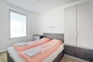 una camera da letto con un letto con lenzuola rosa e una finestra di Villa Oliver 3 Siófok a Siófok
