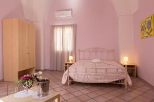 a bedroom with a bed and two tables and a window at Le Dimore dei Messapi in Ugento