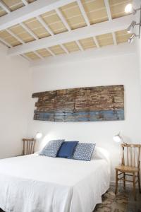 ein Schlafzimmer mit einem weißen Bett und einem Gemälde an der Wand in der Unterkunft Storie di mare in Marsala