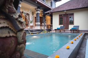 a swimming pool in front of a house at Suparsa's Homestay in Ubud